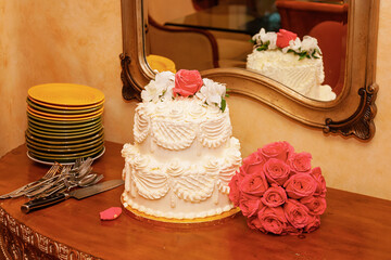 Obraz na płótnie Canvas wedding cake on table with bridal bouquet