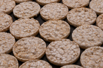 Pattern distribution of rice crackers. Round rice crackers, spread out on a black background. Front or perspective design. Low key photography.