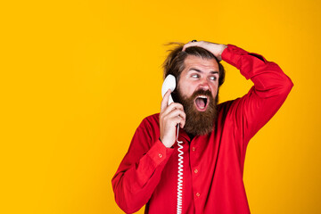 oh no. bearded man wear red shirt. casual male answering call. concept of conversation. man secretary or assistant speak on retro phone. brutal man with telephone. communication. copy space
