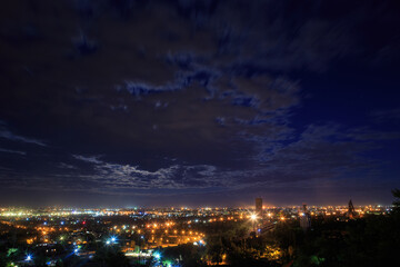 Fototapeta na wymiar Night landscape of a big city with moving clouds