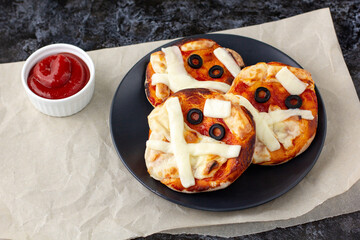 Mini pizza as mummy for kids with cheese, olives and ketchup. Funny crazy Halloween food for children.