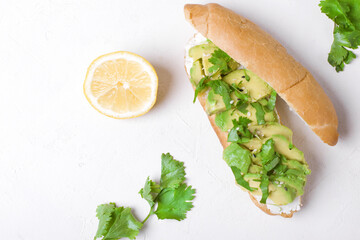 Sandwich with avocado and cream cheese on the white table