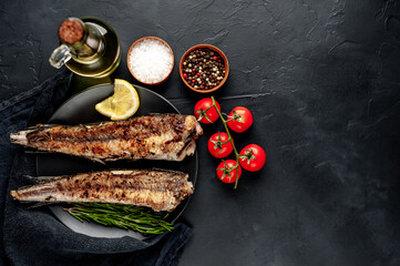 fried hake fish with spices on a stone background 
with copy space for your text