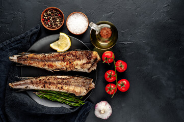 fried hake fish with spices on a stone background 
with copy space for your text