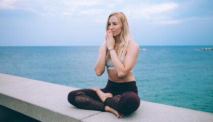 Fototapeta na wymiar Focused woman in yoga asana on seafront