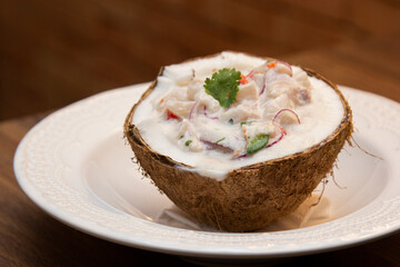 Ceviche served inside fresh coconut. Seafood ceviche, typical dish from Peru