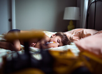 boy sleeping on a bed with toy truck