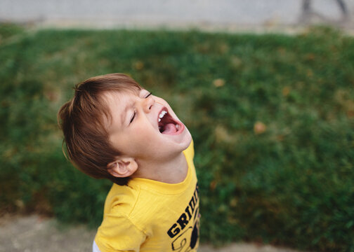 boy looks up at sky and shouts
