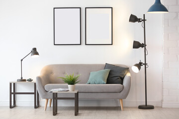 Stylish room interior with empty posters on wall. Mockup for design