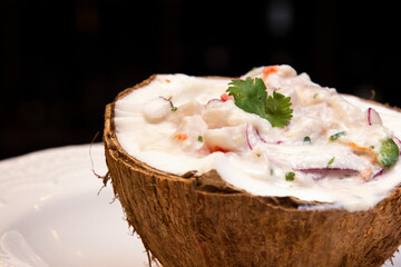 Ceviche served inside fresh coconut. Seafood ceviche, typical dish from Peru