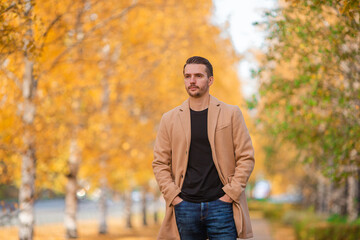 Young man in autumn in the park outdoors