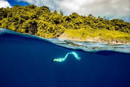 A Mermaid Diving Half Underwater