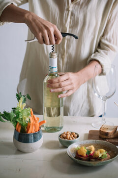 Anonymous woman using corkscrew