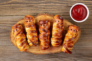 Scary sausage mummies in dough for kids party. Funny crazy Halloween food for children