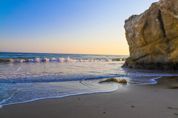 sunset on the beach with large rocks at El Matador beach in Malibu California