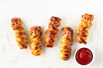 Scary sausage mummies in dough for kids party. Funny crazy Halloween food for children.