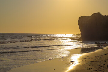 sunset at the beach with large rock formations and waves rolling in at El Matador beach in Malibu...