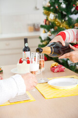 シャンパンを注ぐシニア夫婦の手元