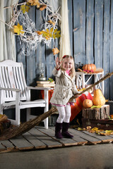 girl depicts a witch on a broomstick in Halloween decoration