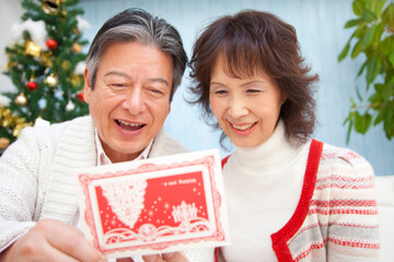 クリスマスカードを見るシニア夫婦