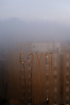 Love written on a cold window