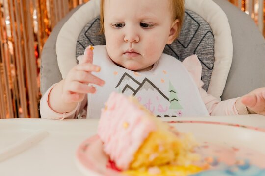 baby girl eating her birthday cake