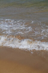 onde che si infrangono su una spiaggia di sabbia