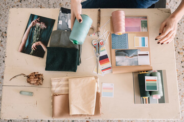 Hands Of Young Woman Choosing Sewing Thread For Moodboard