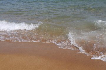 onde che si infrangono su una spiaggia di sabbia