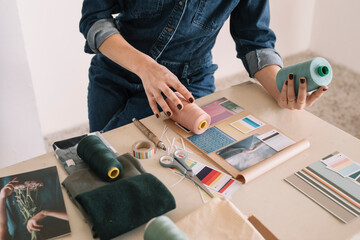 Hands Of Young Woman Choosing Sewing Thread For Moodboard