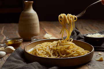 aglio e olio pasta served on a wooden table.