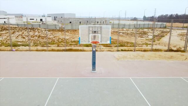 Quick flight to the direction of transparent basketball board in desert at morning
