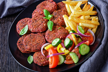 Vegan beetroot cakes with salad and french fries