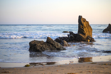 waves rolling in at the beach crashing into the rocks at El Matador beach in Malibu California