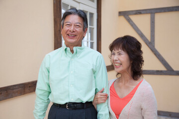 Obraz premium 腕組みをして歩くシニア夫婦