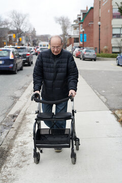 Elderly Man Using Walker Outdoors