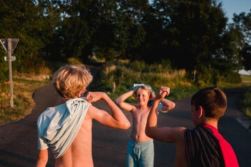 three boys comparing muscles