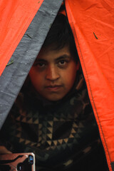 Man in a camping tent looking to the camera