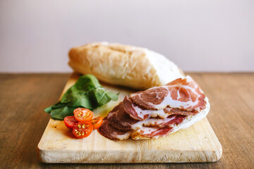 Bondiola de cerdo en tabla con pan rúcula y lechuga para sandwich
