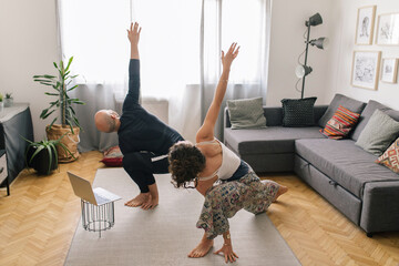 Couple doing yoga at home