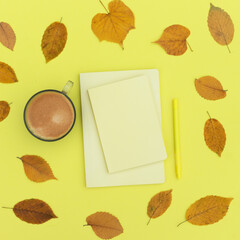 Autumn composition in yellow shades. Flat lay notepad, coffee and autumn dry leaves. To do list Mock up Top view
