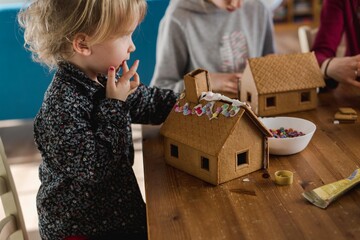 cute toddler eating candy off gingerbread house