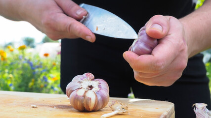 peel the garlic. food preparation. male hands in the frame.