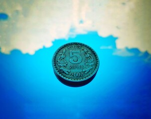 Indian five rupees coin with sky in background