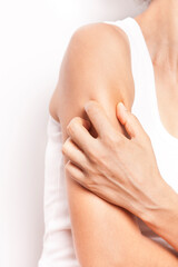 The woman is scratching her arm.