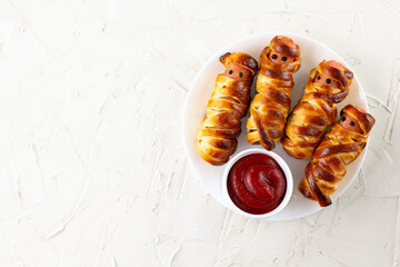Scary sausage mummies in dough for kids party. Funny crazy Halloween food for children.