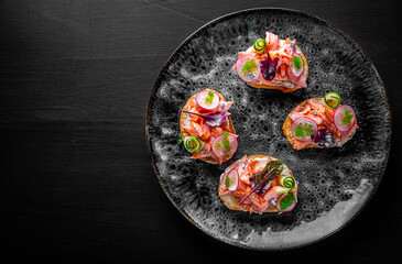 Tasty bruschetta with salmon, cucumber and cream cheese in plate