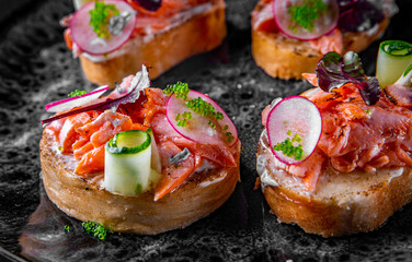 Tasty bruschetta with salmon, cucumber and cream cheese in plate