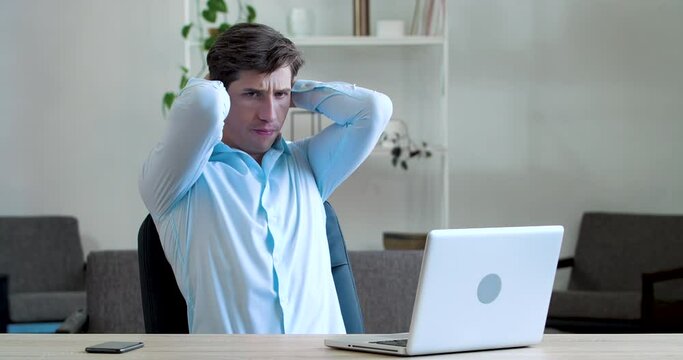 Frustrated young business man feels headache illness, soreness, thinks about difficult problem, worries about bad news or losing money, stress of hard work, fails sitting at table in office workplace