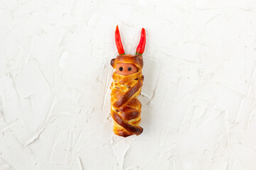 Scary sausage mummies in dough for kids party. Funny crazy Halloween food for children.